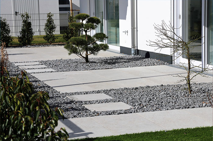 Terrasse modern gestalten mit Beton, Stein und sparsamer Bepflanzung
